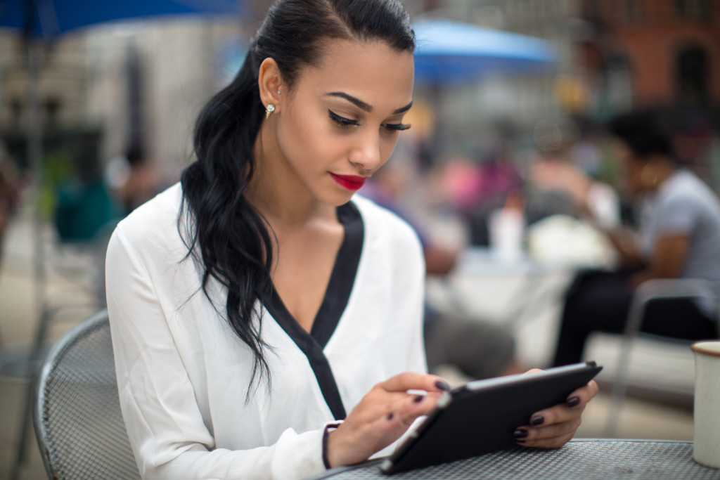 Young beautiful business woman using ipad tablet outdoor